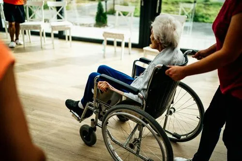 Seniorin im Rollstuhl wird begleitet
